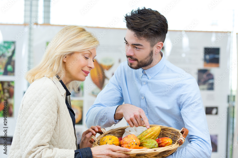 couple choosing fruits and vegetables in market and smiling