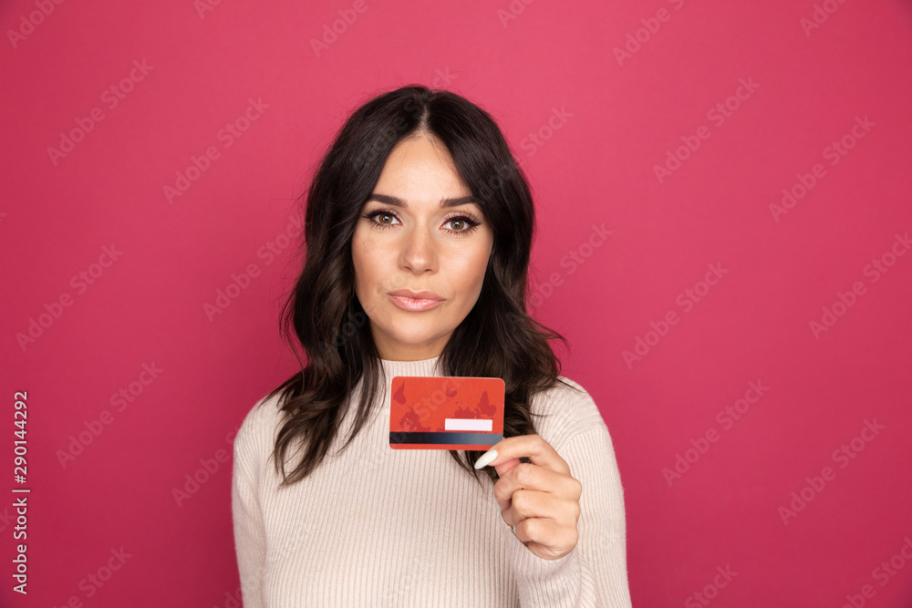 Happy woman with credit card isolated in the pink studio Happy woman with credit card isolated in the pink studio