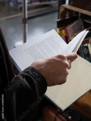 Male hands leaf through book at charity book stall