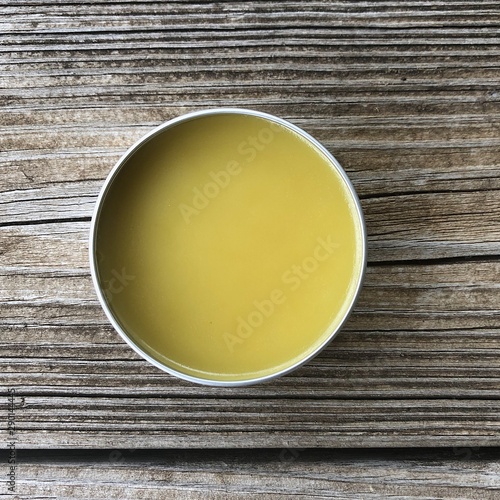 Tin of balm on wooden background