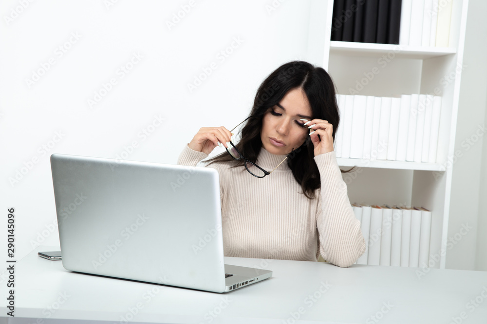 Tired woman secretary feeling bad sitting in the white office cabinet Tired woman secretary feeling bad sitting in the white office cabinet