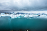 Small blue icebergs in Jokulsarlon ice lake and very gray sky. Iceland