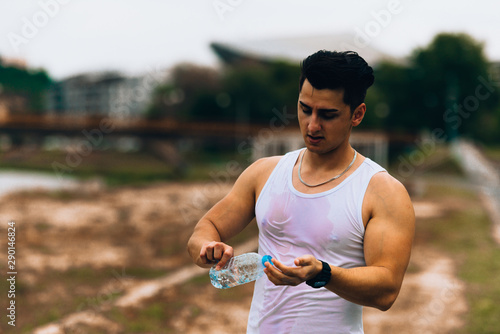 Fototapeta Naklejka Na Ścianę i Meble -  Handsome sportsman resting and holding sport bottle of water