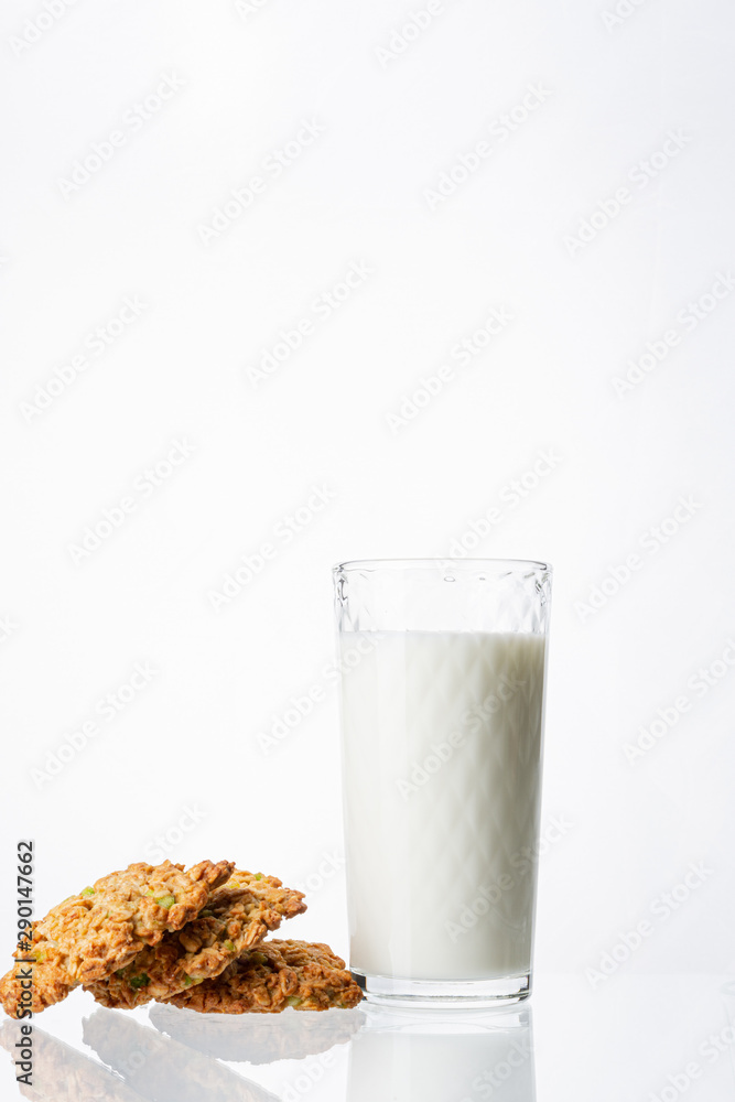 A glass filled with milk on a white background. White drink. Cow's milk. Homemade cookies on a white background. Pyramid of cookies. Cookies on top of each other. A glass filled with milk on a white background. White drink. Cow's milk. Homemade cookies on a white background. Pyramid of cookies. Cookies on top of each other.