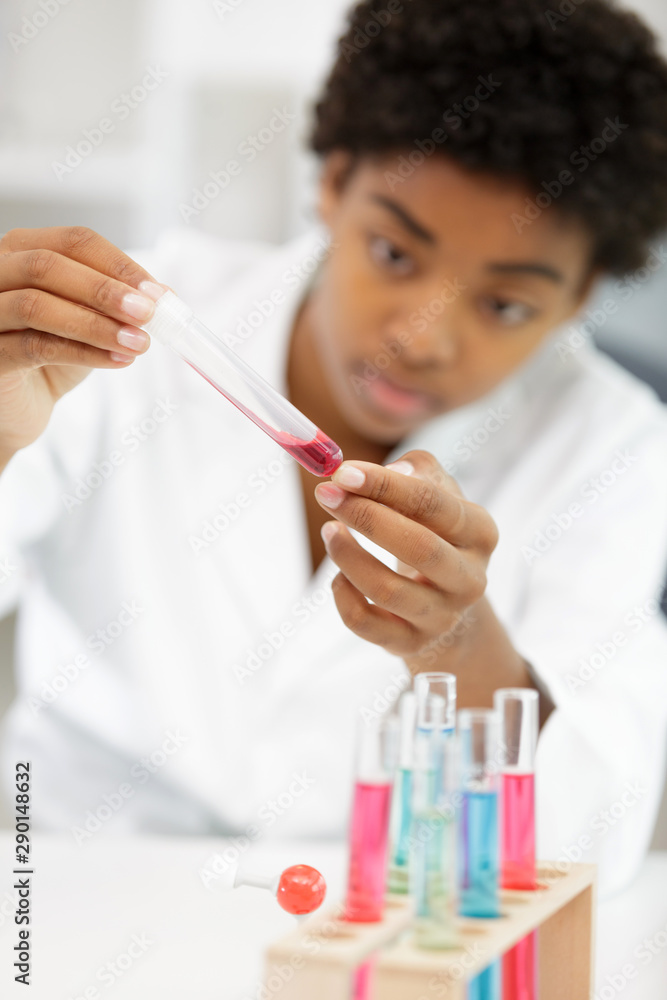 young woman in scientific lab with pipettes and test tubes young woman in scientific lab with pipettes and test tubes