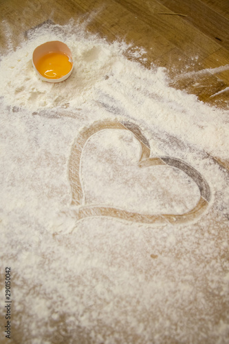 In Mehl gezeichnetes Herz mit Ei