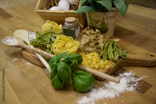 Nudeln auf Brett mit Eiern und Kochlöffeln