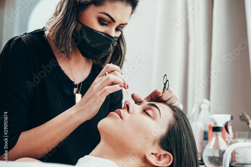 Attractive woman in beauty salon on facial hair removal threading procedure
