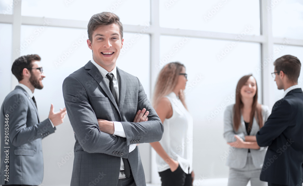 smiling young businessman standing in office. smiling young businessman standing in office.