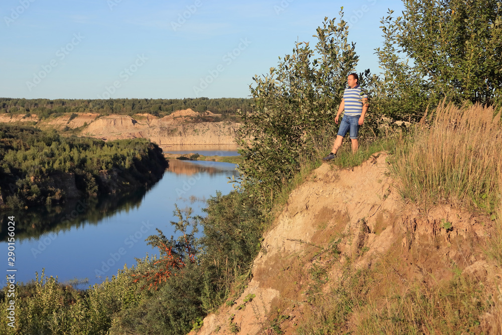 man on a cliff by the river