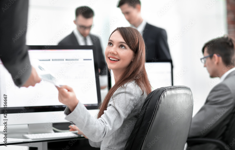 young beautiful woman examines graphics sitting at her workplace young beautiful woman examines graphics sitting at her workplace