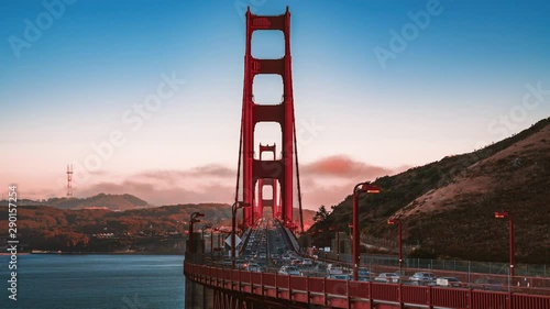 Beautiful time lapse sunset view of the Golden Gate Bridge, traffic and clouds passing down the bridge. Golden Gate National Recreation Area, in San Francisco, California.
