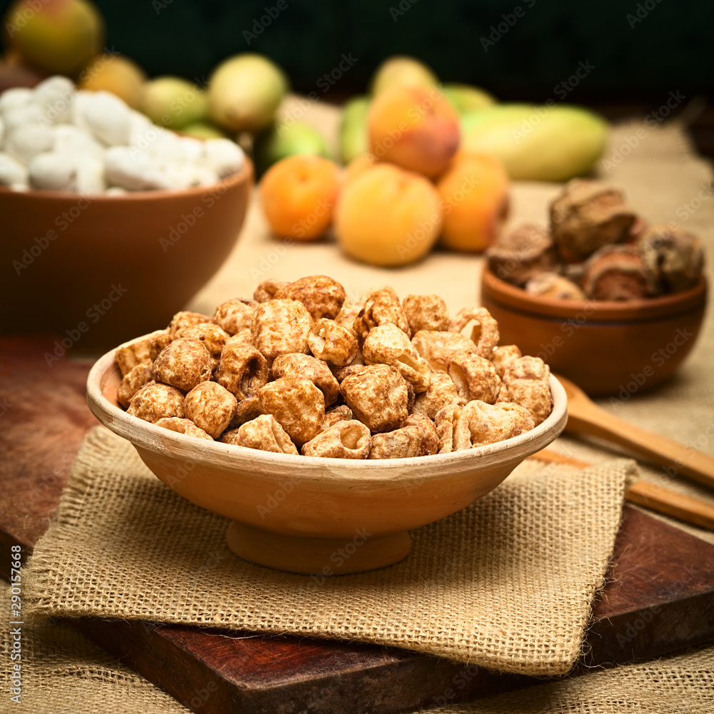 Caramelized roasted pasta, a popular Bolivian snack, served in small clay bowl, photographed with natural light (Selective Focus, Focus one third into the snack) Caramelized roasted pasta, a popular Bolivian snack, served in small clay bowl, photographed with natural light (Selective Focus, Focus one third into the snack)