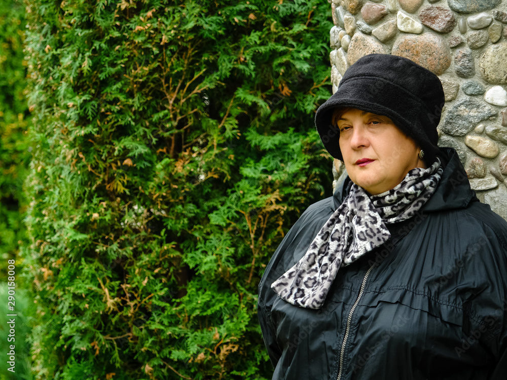 Pensive Mature woman in a black hat resting Pensive Mature woman in a black hat resting