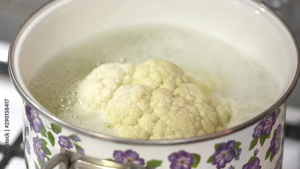 Whole head of cauliflower boiling in large metal pot. Whole head of cauliflower boiling in large metal pot.