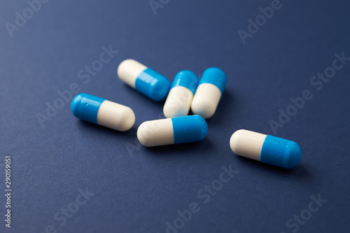 Tri-Creatine Malate capsules. Bodybuilding food supplements on blue paper background. Close up. Copy space. 
