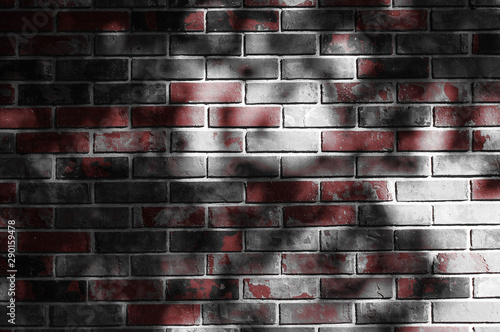 Shadows of tree branches dance along an old brick wall.