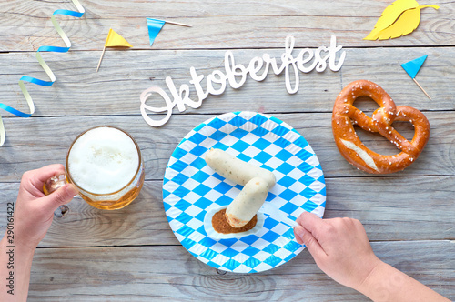 Oktoberfest, traditional festival food: white sausages, pretzel and beer. flat lay on rustic wooden table photo