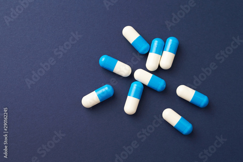 Tri-Creatine Malate capsules. Bodybuilding food supplements on blue paper background. Top view. Copy space. 