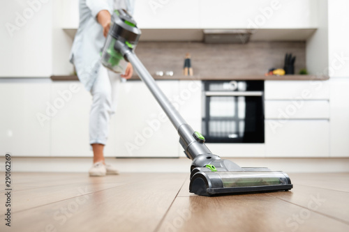 Young Woman Vacuuming the Floor. Vacuuming and Cleaning the House