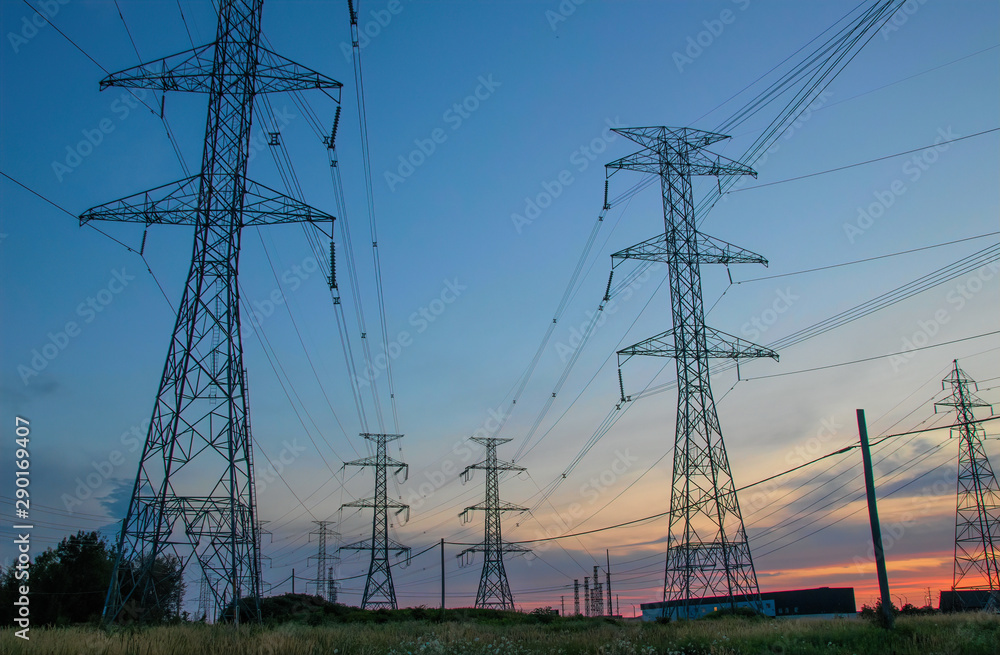 High Voltage Power Pylons against blue and red sky sunset nobody