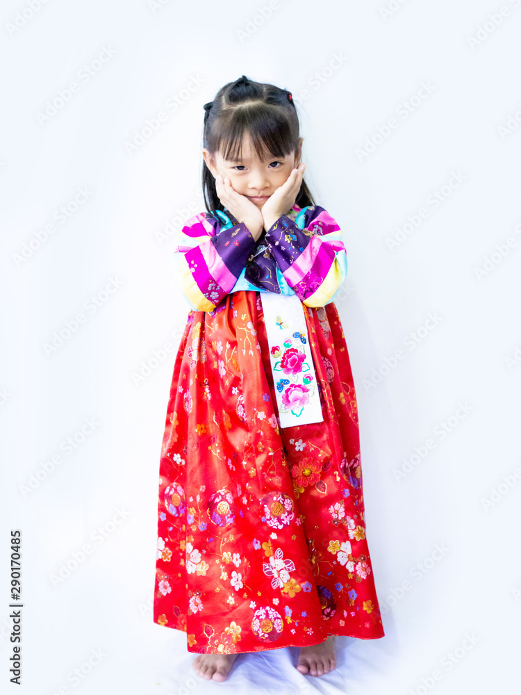 Asian little girl wearing a Korean Traditional Hanbok dress in white background Asian little girl wearing a Korean Traditional Hanbok dress in white background