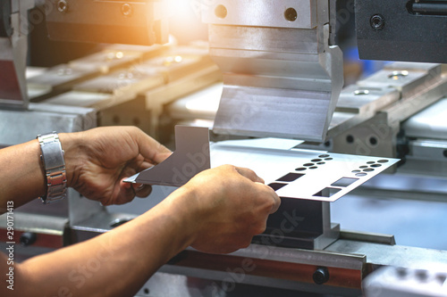Foto Workers bending sheet metal by CNC machines in industrial plants