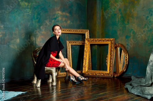 beauty rich brunette woman in luxury interior near empty frames, wearing fashion clothes, lifestyle pretty real people concept
