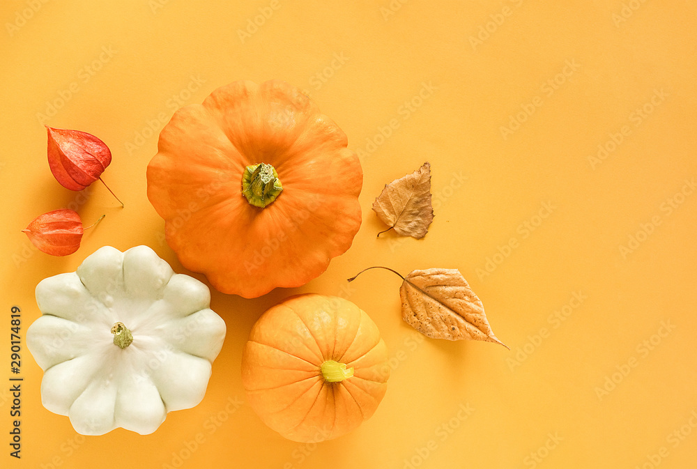 Autumn composition. Fresh three pattypan squash, pumpkin and autumn leaves herbarium on yellow background with copy space. Top view Flat lay Template for your design, invitation, greeting card Autumn composition. Fresh three pattypan squash, pumpkin and autumn leaves herbarium on yellow background with copy space. Top view Flat lay Template for your design, invitation, greeting card