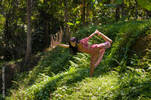 young beautiful Asian Chinese woman doing yoga and relaxation exercise at fresh green forest meditating and enjoying calm and tranquility in harmony