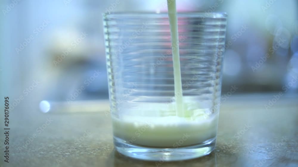 Slow Motion Shot of Milk being poured into a clear glass. Slow Motion Shot of Milk being poured into a clear glass.