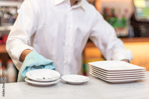 Waiter drying dishes in the restaurant .  photo