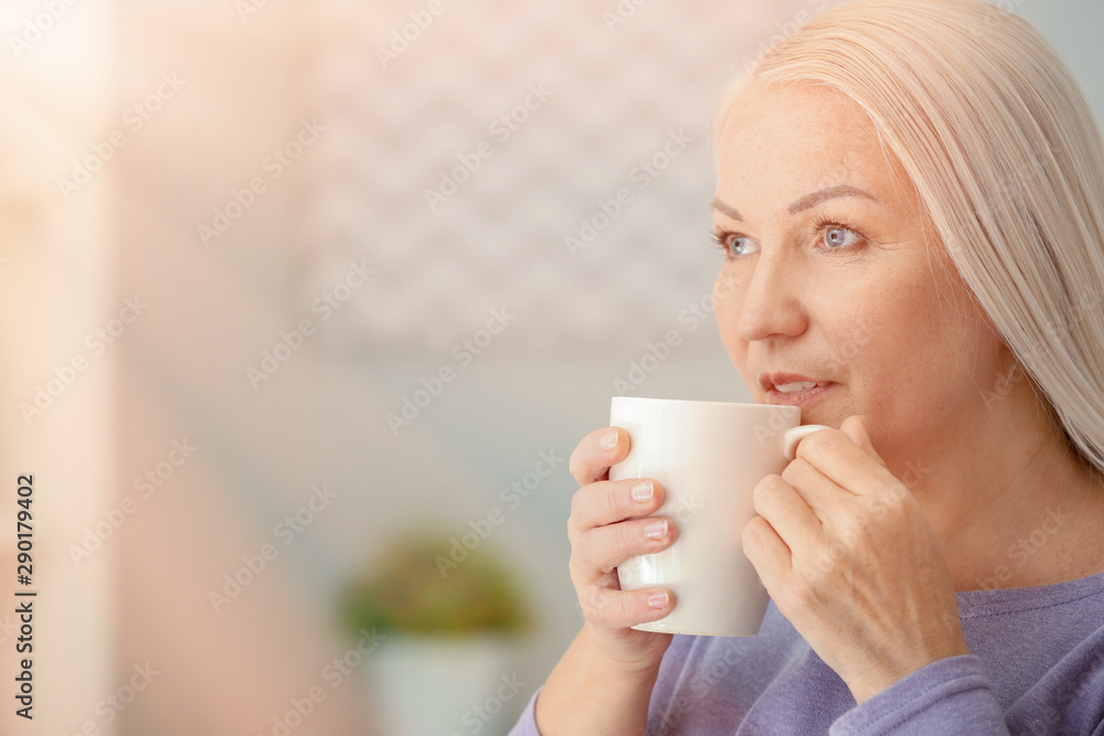 Portrait of beautiful mature woman with cup of tea at home Portrait of beautiful mature woman with cup of tea at home