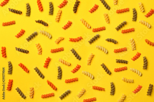 Uncooked fusilli pasta on color background