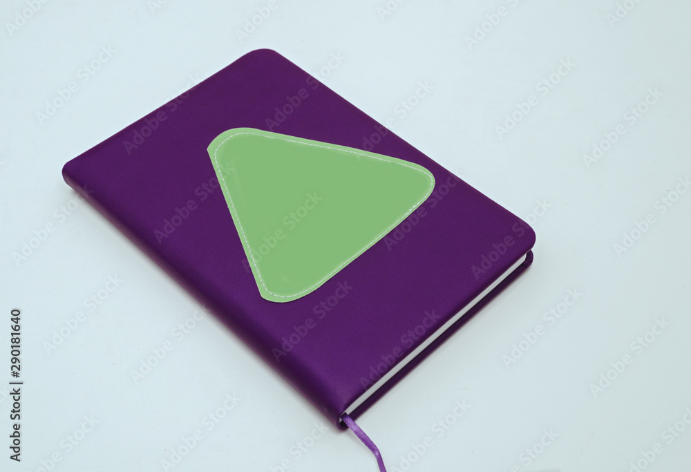 closed notebook in purple for notes on a white background