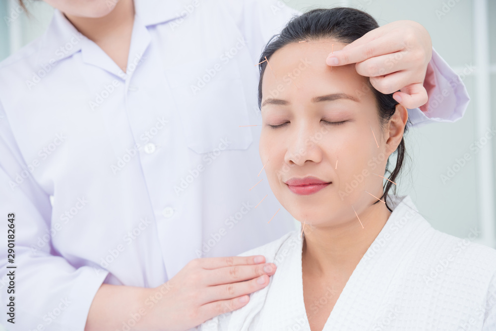 Beautiful asian woman receiving facial acupuncture treatment at clinic ,Alternative medicine concept. Beautiful asian woman receiving facial acupuncture treatment at clinic ,Alternative medicine concept.