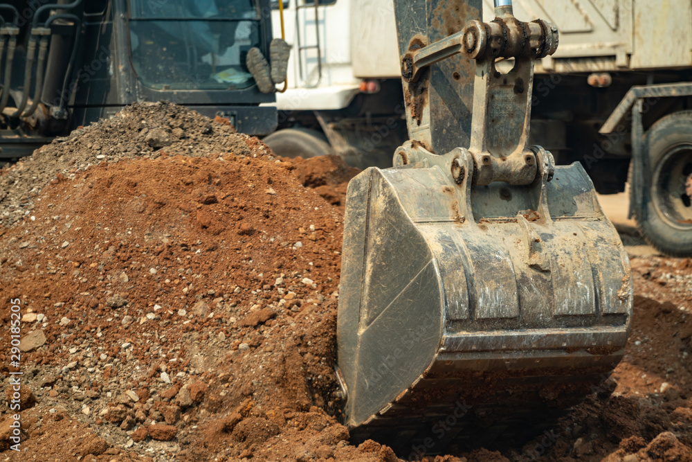 Close up yellow construction excavator working on the construction site. Bulldozer digging excavation earth for highway road build on a building site in summer. Earthwork construction building concept Close up yellow construction excavator working on the construction site. Bulldozer digging excavation earth for highway road build on a building site in summer. Earthwork construction building concept