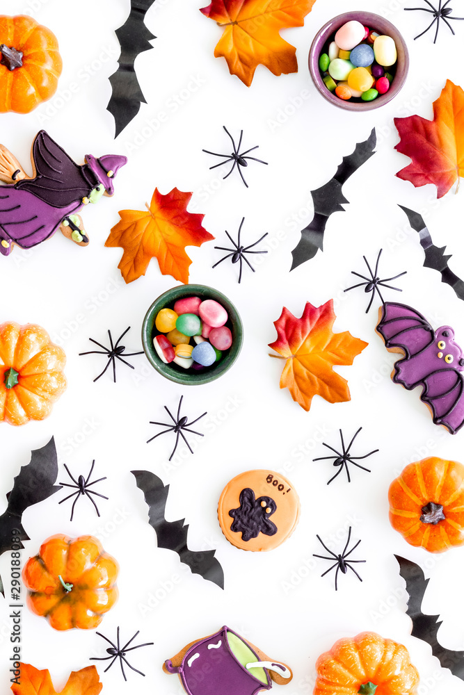 Nice halloween background with sweets. Cookies and pumpkins on white top view pattern Nice halloween background with sweets. Cookies and pumpkins on white top view pattern
