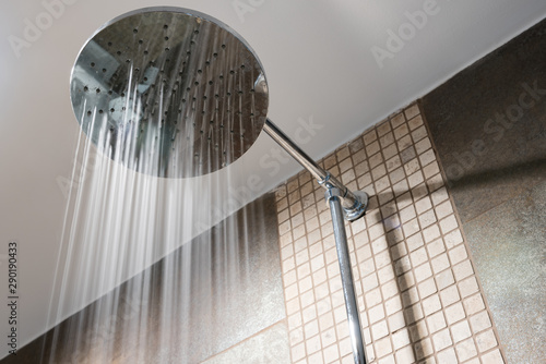 Close up shower head in bathroom with water drops flowing.Sanitary ware for bathroom interior.Running water of shower faucet.