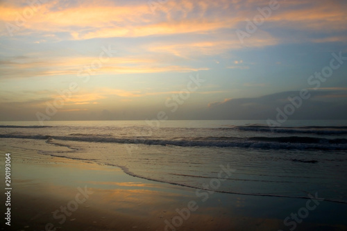 Early morning at the Atlantic beach. Marine background with beautiful colorful sky reflects in a shallow water  before sunrise. Scenic seascape at the Pawleys Island  South Carolina  USA.