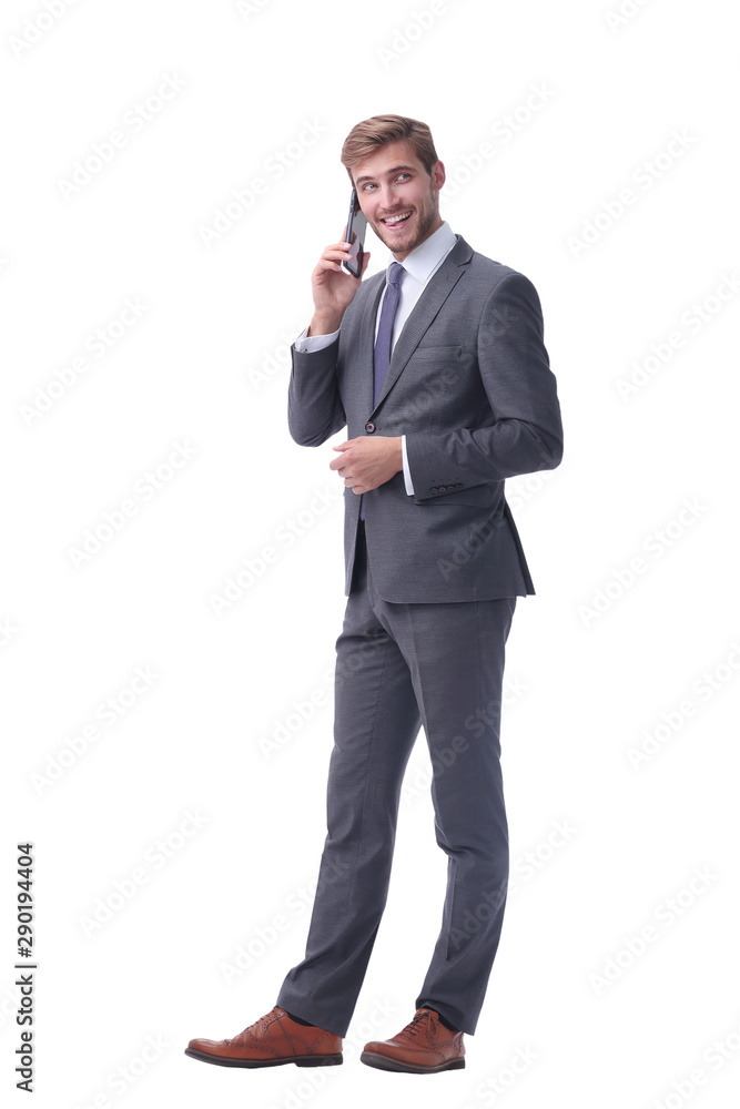 in full growth. confident businessman talking on his smartphone. in full growth. confident businessman talking on his smartphone.