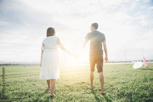 Pregnant wife with her husband enjoy walking outdoor with sunset in morning