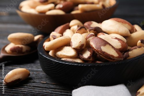 Plate with tasty Brazil nuts on wooden table