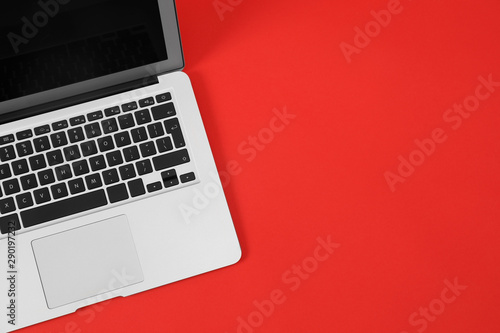 Modern laptop on red background, top view. Space for text