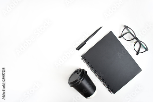 Top view of notebook, pen, eye glasses And coffee on a white background, isolated background.