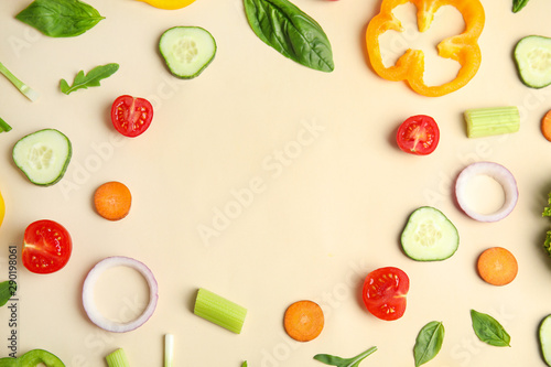 Frame made with fresh salad ingredients on beige background, flat lay. Space for text