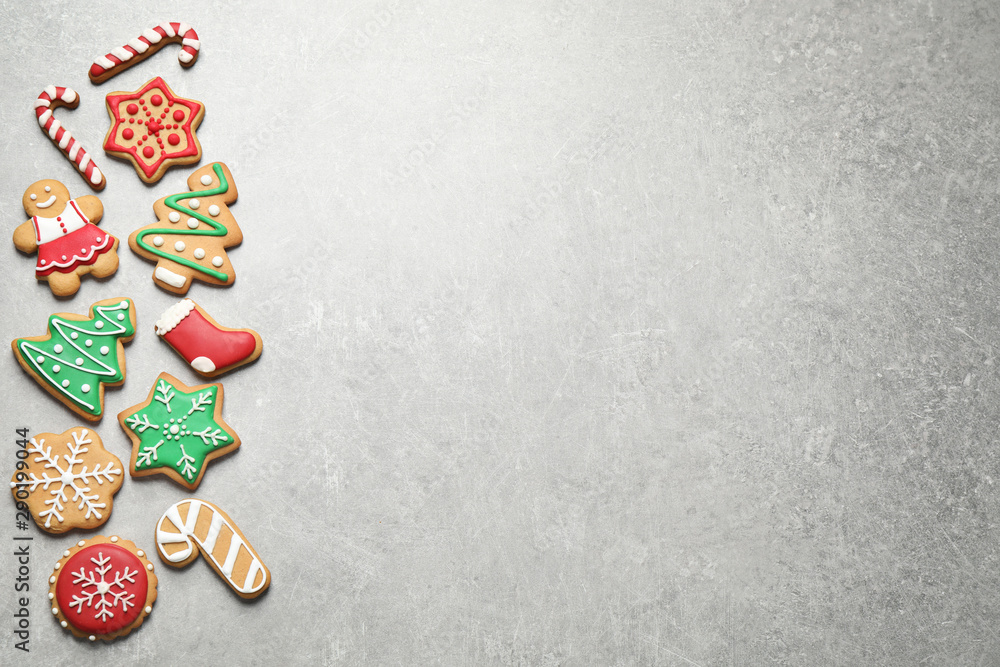 Flat lay composition with tasty homemade Christmas cookies on grey table, space for text