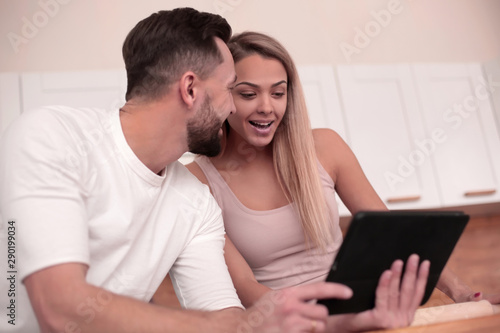 Young couple surfing the web with tablet at home kitchen