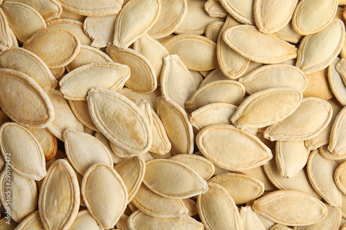 Raw unpeeled pumpkin seeds as background  top view
