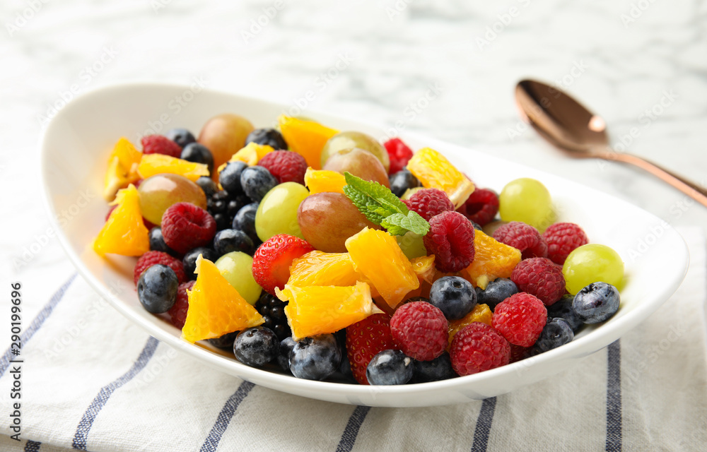 Fresh tasty fruit salad on table, closeup Fresh tasty fruit salad on table, closeup